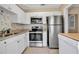 Modern kitchen featuring stainless steel appliances, white cabinets, and a decorative backsplash at 1830 Virginia Dr, Bradenton, FL 34205