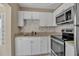 Bright kitchen with modern stainless steel appliances and white cabinets at 1830 Virginia Dr, Bradenton, FL 34205