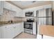 Updated kitchen with white cabinets and stainless steel appliances at 1830 Virginia Dr, Bradenton, FL 34205