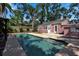 Backyard with a sparkling swimming pool, patio area, and mature landscaping at 1830 Virginia Dr, Bradenton, FL 34205