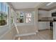 Bright sunroom connects to the kitchen, featuring tile floors, large windows and natural light at 1830 Virginia Dr, Bradenton, FL 34205