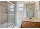 Bathroom featuring tiled shower with glass door and single vanity with a mirror and lighting at 1856 Wharf Rd, Sarasota, FL 34231