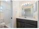 Updated bathroom with modern vanity, large mirror, and walk-in shower with white tiled walls at 1856 Wharf Rd, Sarasota, FL 34231
