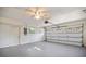 Spacious garage with ceiling fan, door to the backyard, and a roll-up garage door at 1856 Wharf Rd, Sarasota, FL 34231