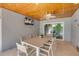 Inviting dining area boasts a wooden ceiling, TV, and sliding glass doors to the outdoor area at 212 72Nd, Holmes Beach, FL 34217