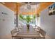 A long table in a covered outdoor dining area with views of the pool and backyard landscaping at 212 72Nd, Holmes Beach, FL 34217