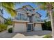Coastal home featuring two-car garage, covered balconies, and tropical landscaping for a relaxing island lifestyle at 212 72Nd, Holmes Beach, FL 34217