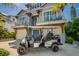 An attractive two-story home with a golf cart parked in the sand in front of the garage at 212 72Nd, Holmes Beach, FL 34217