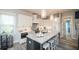 Modern kitchen features a large island, stainless appliances, and white cabinets, creating a bright and inviting space at 212 72Nd, Holmes Beach, FL 34217
