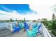 A roof deck with colorful Adirondack chairs and open views of the surrounding neighborhood and sky at 212 72Nd, Holmes Beach, FL 34217