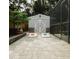 Backyard featuring a shed, cornhole game, foliage, and a screened-in pool area with a privacy fence at 2300 Stratford Dr, Sarasota, FL 34232