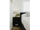 This bedroom shows a bedside table with stylish lamp, decorative plant, and modern minimalist design elements at 2300 Stratford Dr, Sarasota, FL 34232