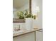 Stylized hallway with textured table, eye-catching mirror, sconce, and tasteful decor at 2300 Stratford Dr, Sarasota, FL 34232