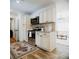 Stylish kitchen featuring stainless steel appliances, white cabinetry, and wood flooring at 2300 Stratford Dr, Sarasota, FL 34232