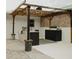 Charming outdoor kitchen under a pergola with stone and wood accents at 2300 Stratford Dr, Sarasota, FL 34232