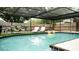 Sparkling pool within screened enclosure, complemented by lounge chairs at 2300 Stratford Dr, Sarasota, FL 34232