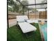 Relaxing poolside seating area with artificial grass within screened enclosure at 2300 Stratford Dr, Sarasota, FL 34232