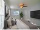 This staged bedroom features a ceiling fan, large window, and neutral colors to create a calming space at 2402 16Th W St, Palmetto, FL 34221
