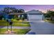 Charming home featuring a manicured lawn, beautiful landscaping, and an attached two-car garage at 2402 16Th W St, Palmetto, FL 34221