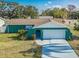 Inviting teal home features a two-car garage, landscaped yard, and walkway to the front door at 2402 16Th W St, Palmetto, FL 34221