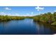 Scenic community lake with lush trees lining the shore under a sunny sky at 2402 16Th W St, Palmetto, FL 34221