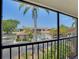 Balcony view overlooking the community pool and well-maintained landscaping on a bright sunny day at 2415 Bayshore Gardens Pkwy # 8, Bradenton, FL 34207