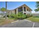 Well-maintained building exterior featuring lush landscaping, a private screened balcony, and ample parking at 2415 Bayshore Gardens Pkwy # 8, Bradenton, FL 34207