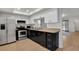 Clean kitchen featuring white cabinets, stainless steel appliances, black accents and wood-look flooring at 2415 Bayshore Gardens Pkwy # 8, Bradenton, FL 34207