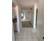 Open hallway leading to a sunlit living area with neutral tile and carpet at 2808 60Th W Ave # 1924, Bradenton, FL 34207
