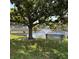 View of the serene pond and water fountain from under a tree with a bench at 2808 60Th W Ave # 1924, Bradenton, FL 34207