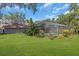 Spacious backyard with green lawn, screened pool area and lush greenery at 3021 Leila Estelle Dr, Plant City, FL 33565