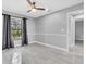 Well-lit bedroom with tile floors, ceiling fan, and a window with dark curtains at 3021 Leila Estelle Dr, Plant City, FL 33565