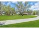 Expansive green lawn with mature trees leading to the home and separate garage at 3021 Leila Estelle Dr, Plant City, FL 33565