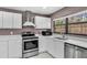 Kitchen featuring stainless appliances, white cabinets, and view of the backyard at 3021 Leila Estelle Dr, Plant City, FL 33565