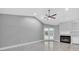 Open living room with a fireplace, ceiling fan and view of the backyard pool through french doors at 3021 Leila Estelle Dr, Plant City, FL 33565