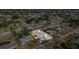 An aerial view of the blue home and its surrounding neighborhood with mature trees and clear blue skies at 3095 Pinetree St, Port Charlotte, FL 33952