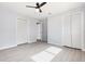 Spacious bedroom with light wood flooring, ceiling fan, and a closet providing ample storage space at 3095 Pinetree St, Port Charlotte, FL 33952