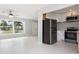Modern kitchen with white cabinets, stainless steel appliances, and an adjacent open living space at 3095 Pinetree St, Port Charlotte, FL 33952