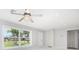 Bright living room featuring large windows, neutral paint, and a modern ceiling fan with crystal accents at 3095 Pinetree St, Port Charlotte, FL 33952