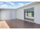 Outdoor patio featuring a tile floor, sliding glass doors, and a white wall, creating a private and versatile area at 3095 Pinetree St, Port Charlotte, FL 33952