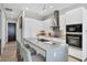 Sleek, modern kitchen with gray countertops, white cabinetry, stainless steel appliances, and bar seating at 33 S Palm Ave # 1403, Sarasota, FL 34236