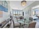 Open living and dining area with floor-to-ceiling windows, stylish chandelier, and comfortable seating at 33 S Palm Ave # 1403, Sarasota, FL 34236
