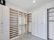 Bright walk-in closet featuring custom shelving and storage solutions with marble floors at 33 S Palm Ave # 1702, Sarasota, FL 34236