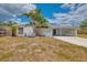 Inviting single-story home featuring a carport and freshly painted exterior with tropical landscaping at 3599 Bali Dr, Sarasota, FL 34232