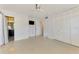 Main bedroom featuring a ceiling fan, TV, double-door closet, and adjoining bathroom at 3599 Bali Dr, Sarasota, FL 34232