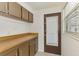 Mud room featuring built-in cabinets, laminate countertop, and access to the exterior at 3599 Bali Dr, Sarasota, FL 34232