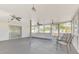 Enclosed sunroom featuring fans, lighting, and outside access at 3599 Bali Dr, Sarasota, FL 34232