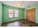 Green bedroom with hardwood floors, closet, and large window allowing ample natural light at 3610 54Th W St # B4, Bradenton, FL 34209