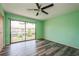 An airy bedroom with modern gray flooring, ceiling fan, and sliding door to balcony at 3610 54Th W St # B4, Bradenton, FL 34209