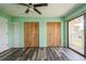 This bedroom features sleek flooring, wooden closets, and a sliding door leading to a balcony at 3610 54Th W St # B4, Bradenton, FL 34209